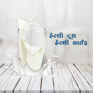 A glass of milk with a splash, on a wooden surface.