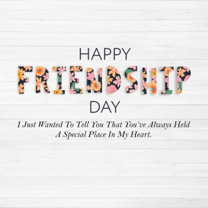 Happy Friendship Day text with floral design on a wood background