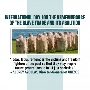 Memorial statues representing victims of the slave trade with a quote from UNESCO Director-General Audrey Azoulay.