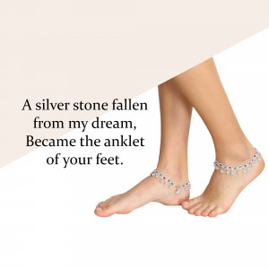 Close-up of a woman's feet wearing a delicate silver anklet with colorful stones.