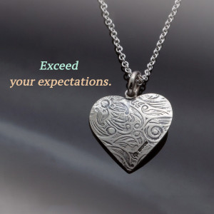 Silver heart pendant necklace with intricate floral design
