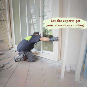 A technician installing a glass sliding door in a home.