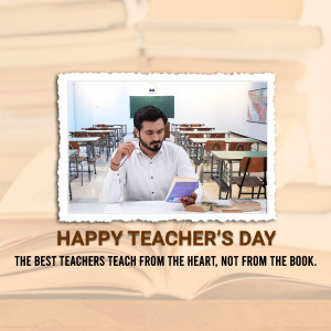 A teacher sitting at a desk in a classroom with a book, celebrating Teacher's Day.