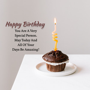 A chocolate cupcake with a lit spiral candle and 'Happy Birthday' text.