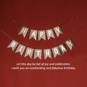 A banner with the text 'HAPPY BIRTHDAY' hanging against a red background.