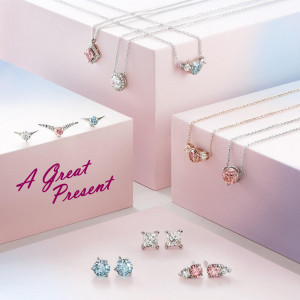Assortment of silver and rose gold necklaces and earrings with colorful gemstones.