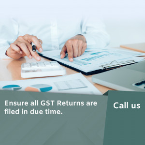 Person working on GST returns with calculator and documents