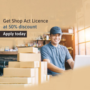 Man working on laptop with boxes, promoting Shop Act Licence discount
