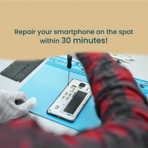 Close-up of a technician repairing a smartphone with tools on a workbench.
