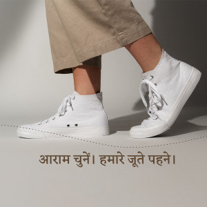 Close-up of white high-top sneakers with a person walking