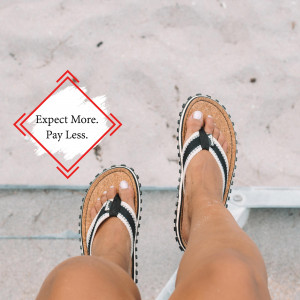 Close-up of feet wearing black and white striped flip-flops on a sandy beach with a promotional graphic.