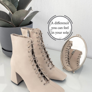 Beige lace-up booties with a square heel and a mirror reflecting the shoe.