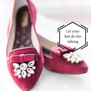 Close-up of a pair of red velvet loafers with jeweled details