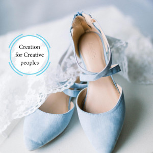 Pair of light blue heels on a white lace surface