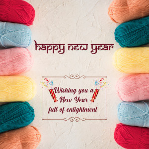 Colorful balls of yarn arranged around a 'Happy New Year' greeting.