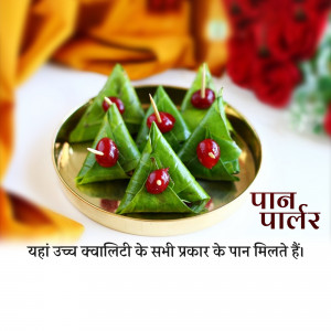 Close-up of triangular paan (betel leaf) bites with cherries on top, served on a gold plate.