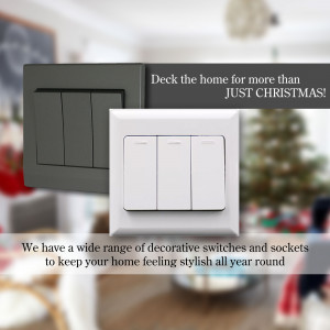 Close-up of decorative light switches and sockets on a wall with a blurred Christmas tree in the background.