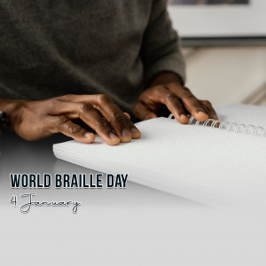 Close-up of a person with dark skin reading Braille from a spiral notebook, with 'World Braille Day - January 4th' text overlay.