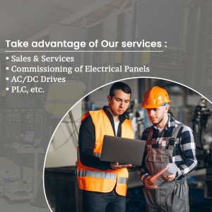 Two electricians reviewing data on a laptop in an industrial setting.