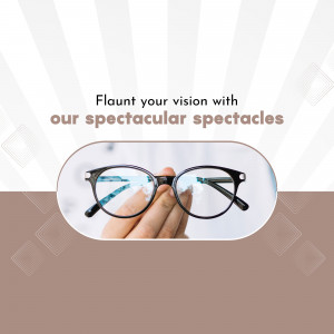A hand holding up a pair of black-framed glasses against a brown and white striped background.