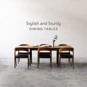 A dining table set with wooden chairs and a vase with a plant.