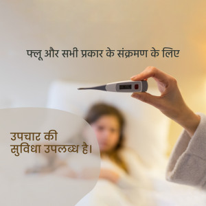 A hand holding a thermometer with a blurred background of a sick person in bed.