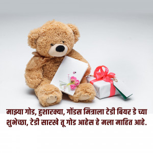 A fluffy teddy bear holding a card and sitting next to a gift box with a ribbon.