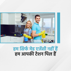 A smiling couple wearing cleaning gloves and holding cleaning supplies in a modern kitchen.