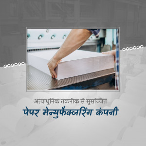 Worker placing paper sheets on a large format printer in a manufacturing facility.