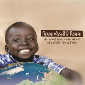 A smiling young boy holding a globe with text in Punjabi.
