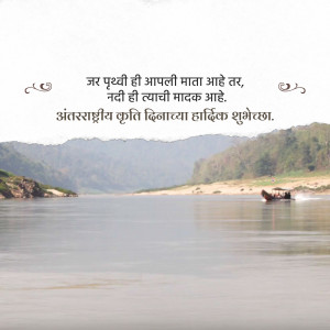 Scenic river landscape with Marathi text wishing a Happy International River Day.