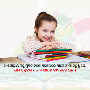 A young girl smiling while sitting at a table with books and school supplies.