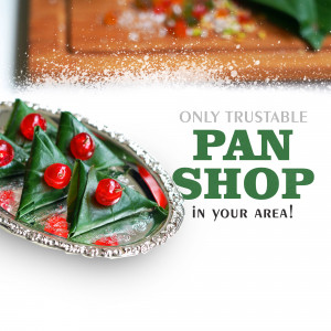Close-up of beautifully arranged paan (betel leaf preparation) with cherries on a silver platter.