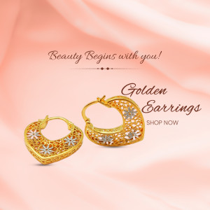 Close-up of golden hoop earrings with floral details on a pink background