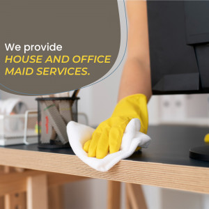 Person wearing yellow gloves cleaning an office desk with a white cloth.