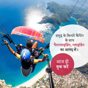 A person paragliding over a beautiful coastal landscape with turquoise water and mountains.