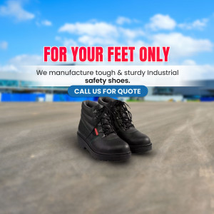 Black industrial safety shoes on a concrete surface with a blue sky background