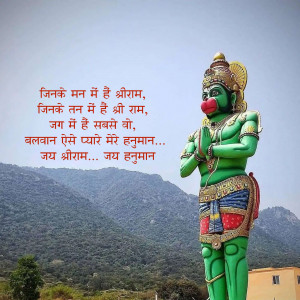 Statue of Hanuman with a mountain backdrop and text in Hindi