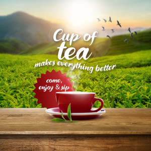 Red teacup on a wooden surface with a scenic landscape background