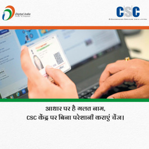Image showing a hand holding an Aadhaar card with a laptop in the background, promoting Aadhaar name correction services at CSC centers.