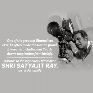 Black and white image of Satyajit Ray with a film camera, commemorating his death anniversary.