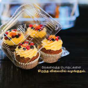 Close-up of four beautifully decorated cupcakes in a clear plastic container.