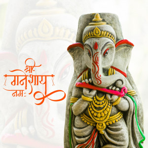 Close-up of a grey Ganesha idol with red and gold accents and the Sanskrit phrase 'Shree Ganeshaya Namah'