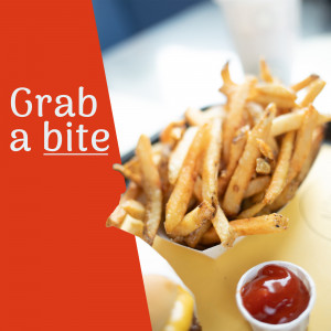 Close-up of crispy french fries with ketchup and dipping sauce