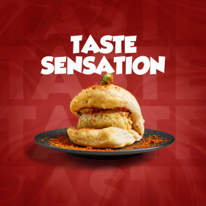 A delicious-looking burger on a black plate with a red spice sprinkle.