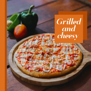 Close-up of a grilled pizza with cheese and toppings on a wooden serving board