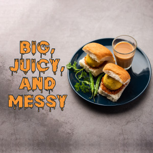 Close-up of two Vada Pavs with a glass of tea on a blue plate
