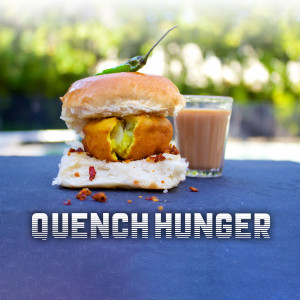Close-up of a Vada Pav with a glass of chai