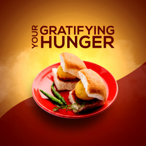Close-up of Vada Pav on a red plate with green chilies