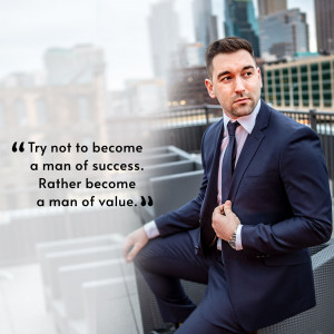 A professional man in a suit looking thoughtfully into the distance with a motivational quote.